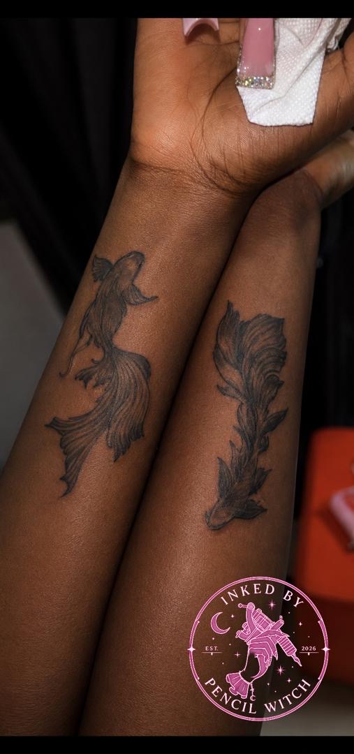 Two matching betta fish tattoos on a couple's forearms