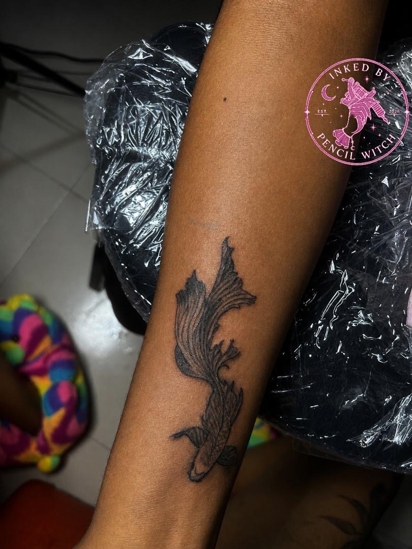 Flowing koi fish tattoo on inner forearm