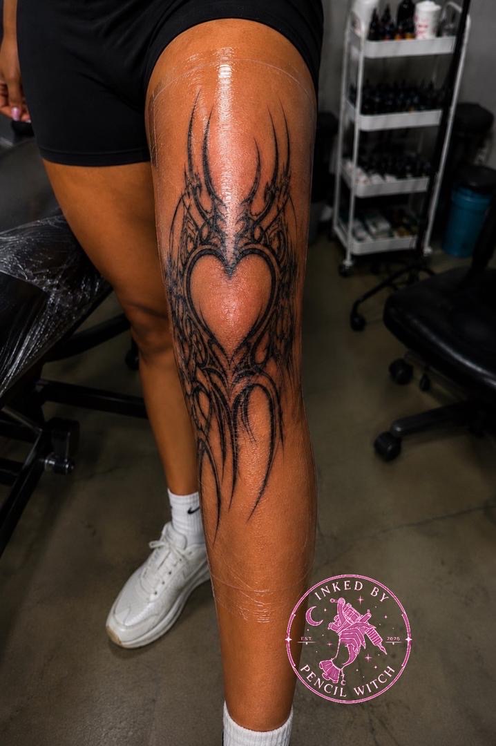 Full-leg ornamental tattoo descending from thigh to ankle