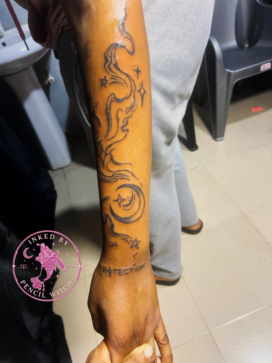 Celestial forearm sleeve — drifting smoke, crescent moon, stars, the number 04, and the word PROTECTION lettered near the wrist